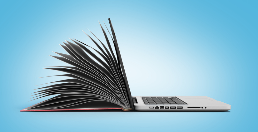 Aufgeklappter Laptop mit einem aufgeschlagenem Buch auf der Rückseite